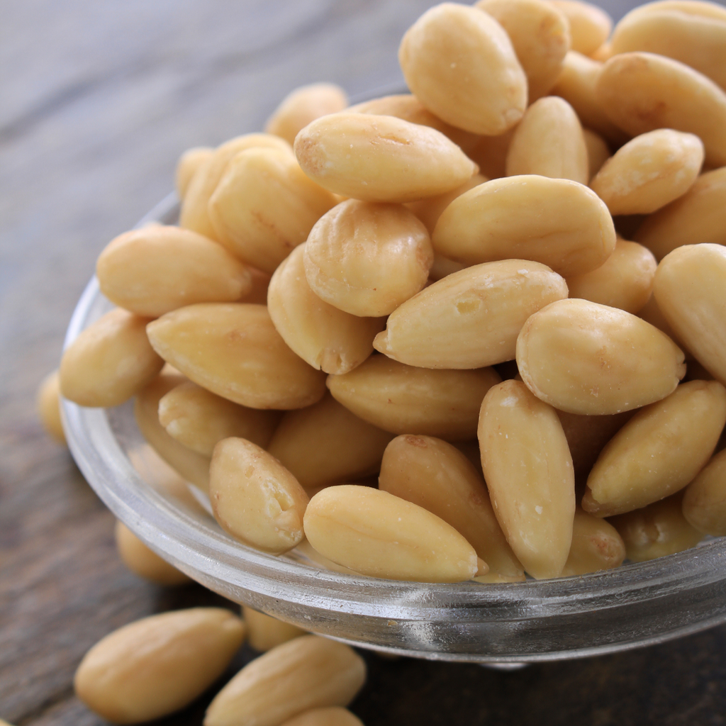 Pine nuts in a glass bowl on a wooden surface