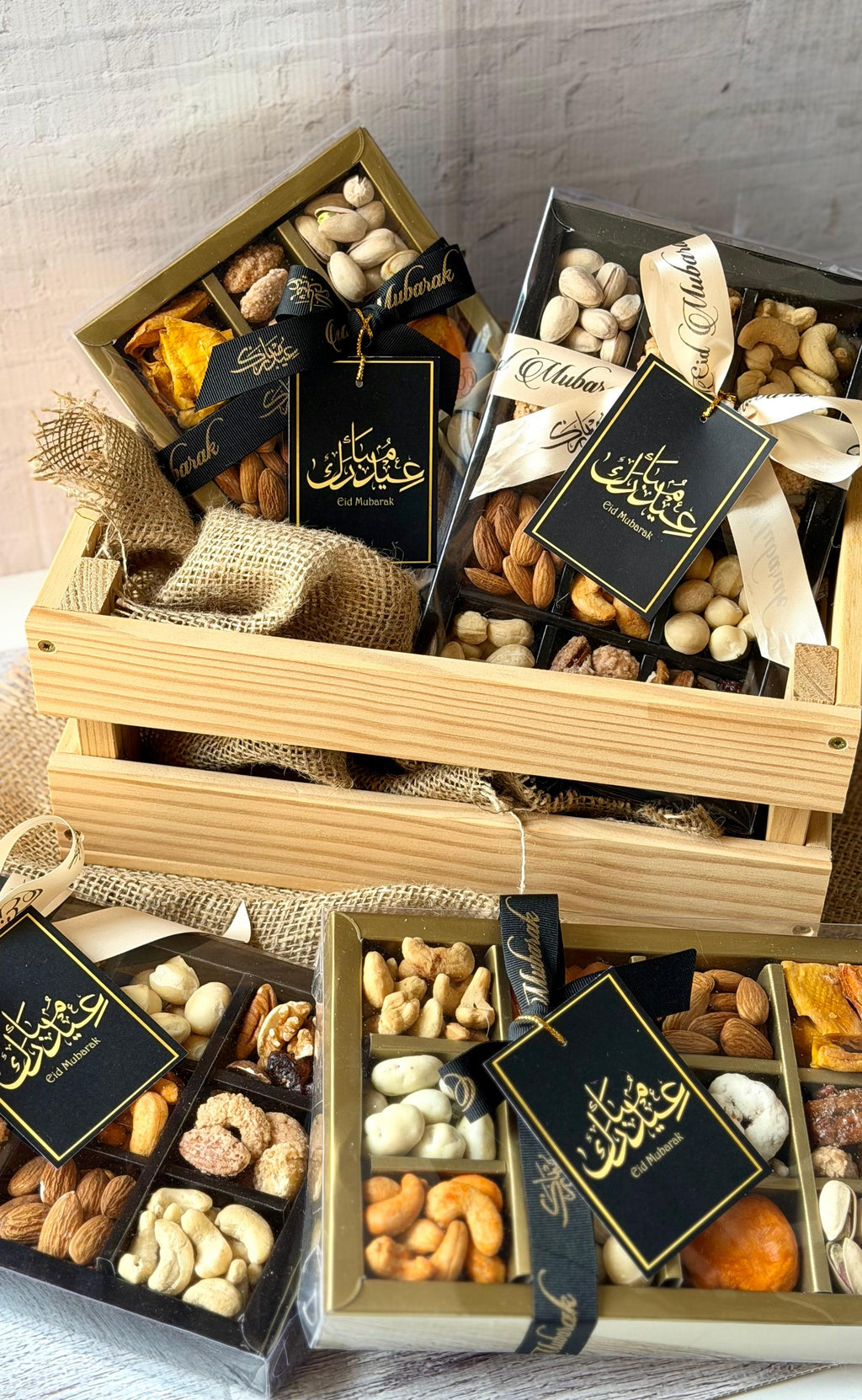 Assorted dried fruits and nuts in gift boxes with visible branding on a wooden crate.