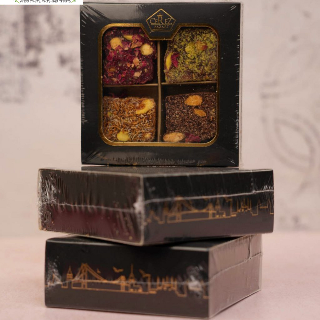 Black tea box with four compartments containing 4 different types of Turkish Dleights on a light background.