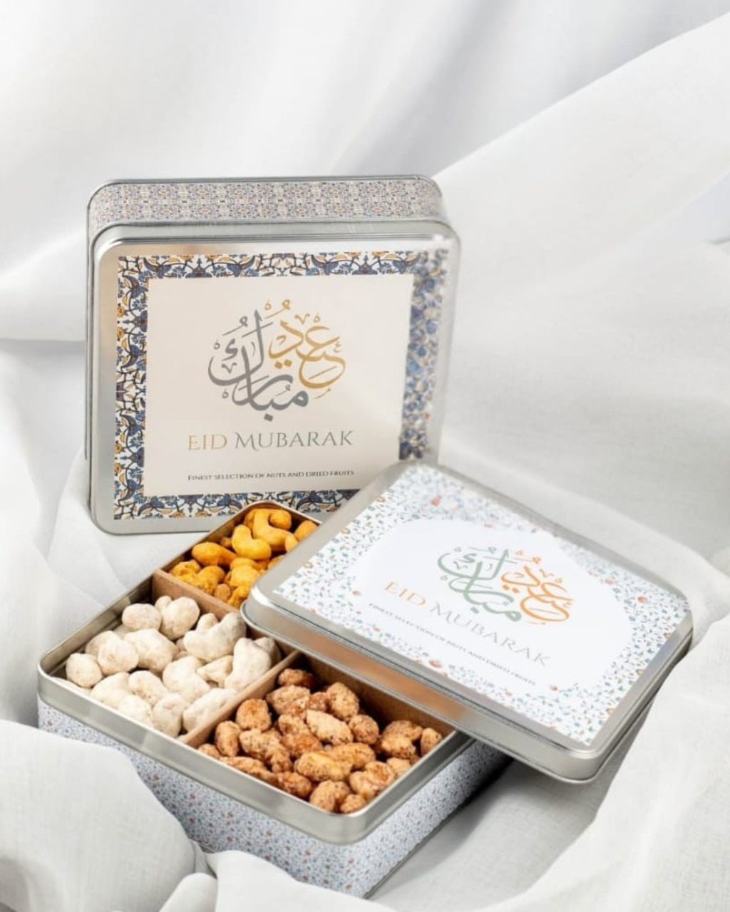 Decorative tin with 'Lud Mubarak' text, filled with nuts on a white background